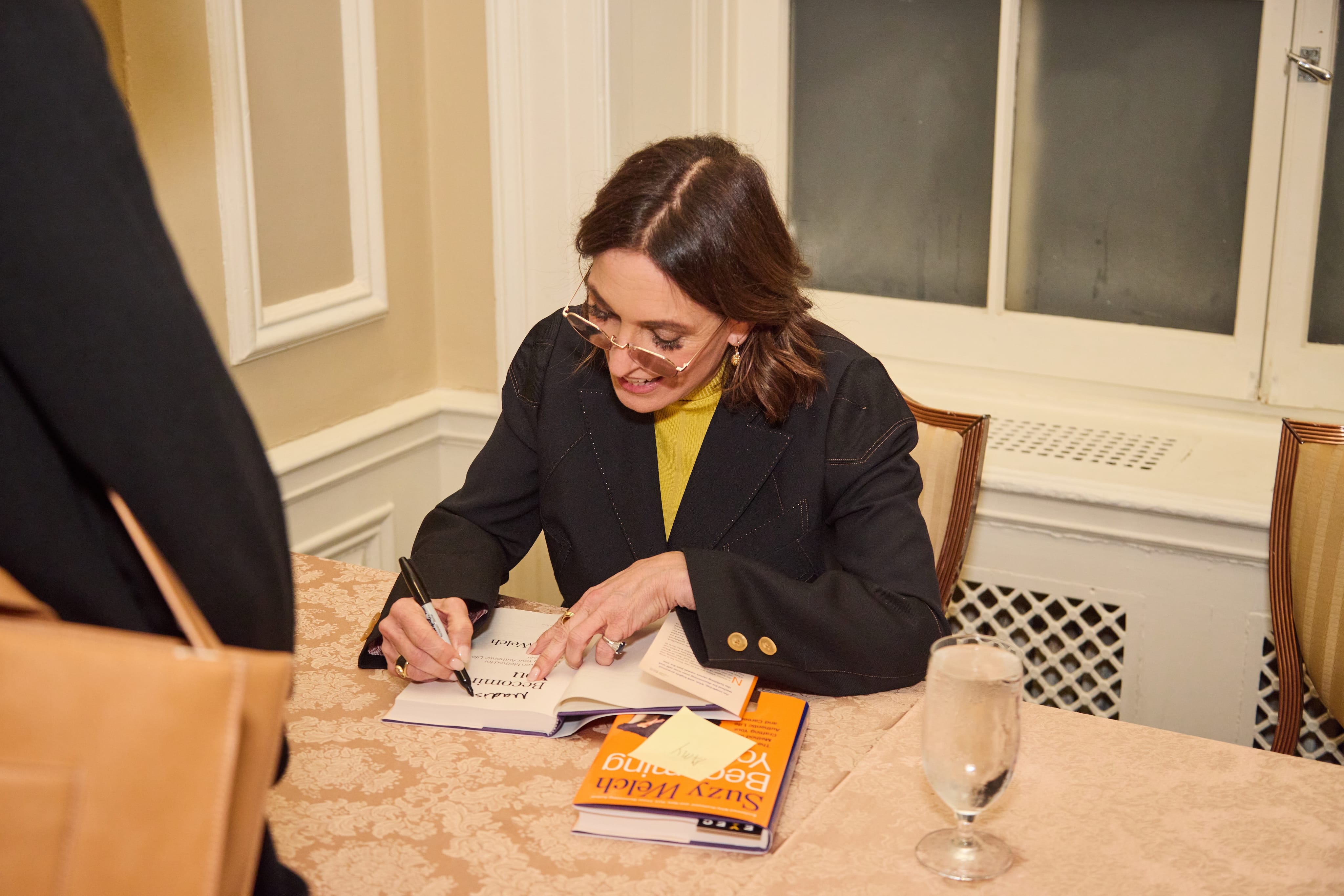 Suzy signing books for newsletter